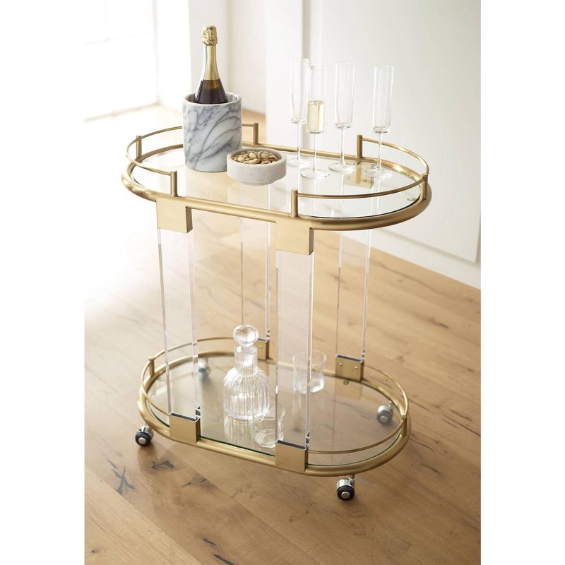 55 Downing Street Adaline 29 1/2" Wide Clear Acrylic and Gold Oval Bar Cart
