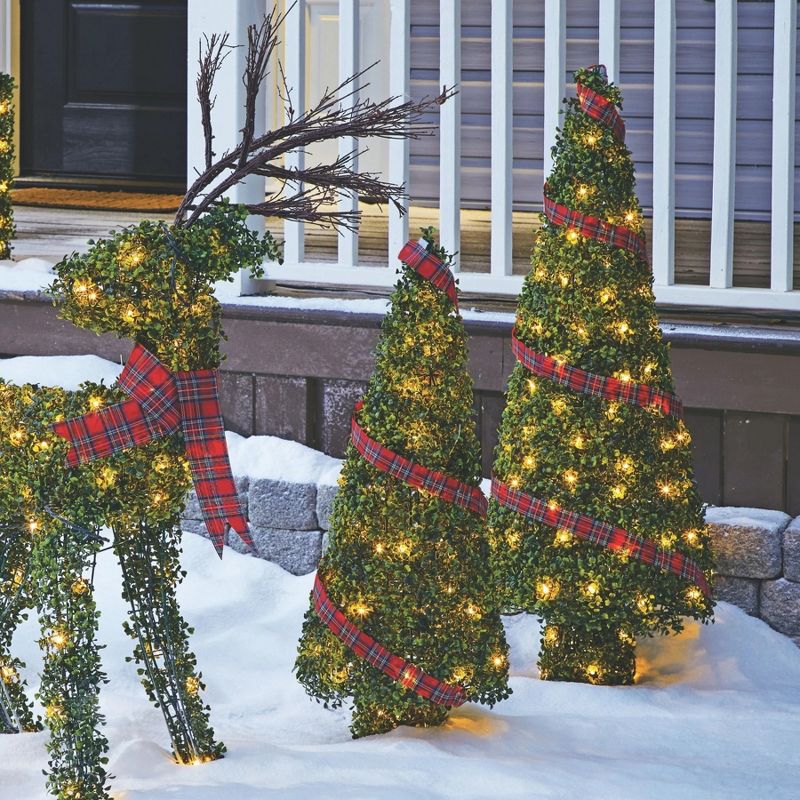 NOMA Pre Lit Incandescent Light Up Winter Green Garden Cone Trees Outdoor Decorations with Red Ribbon Details and Yard Stakes, Set of 2