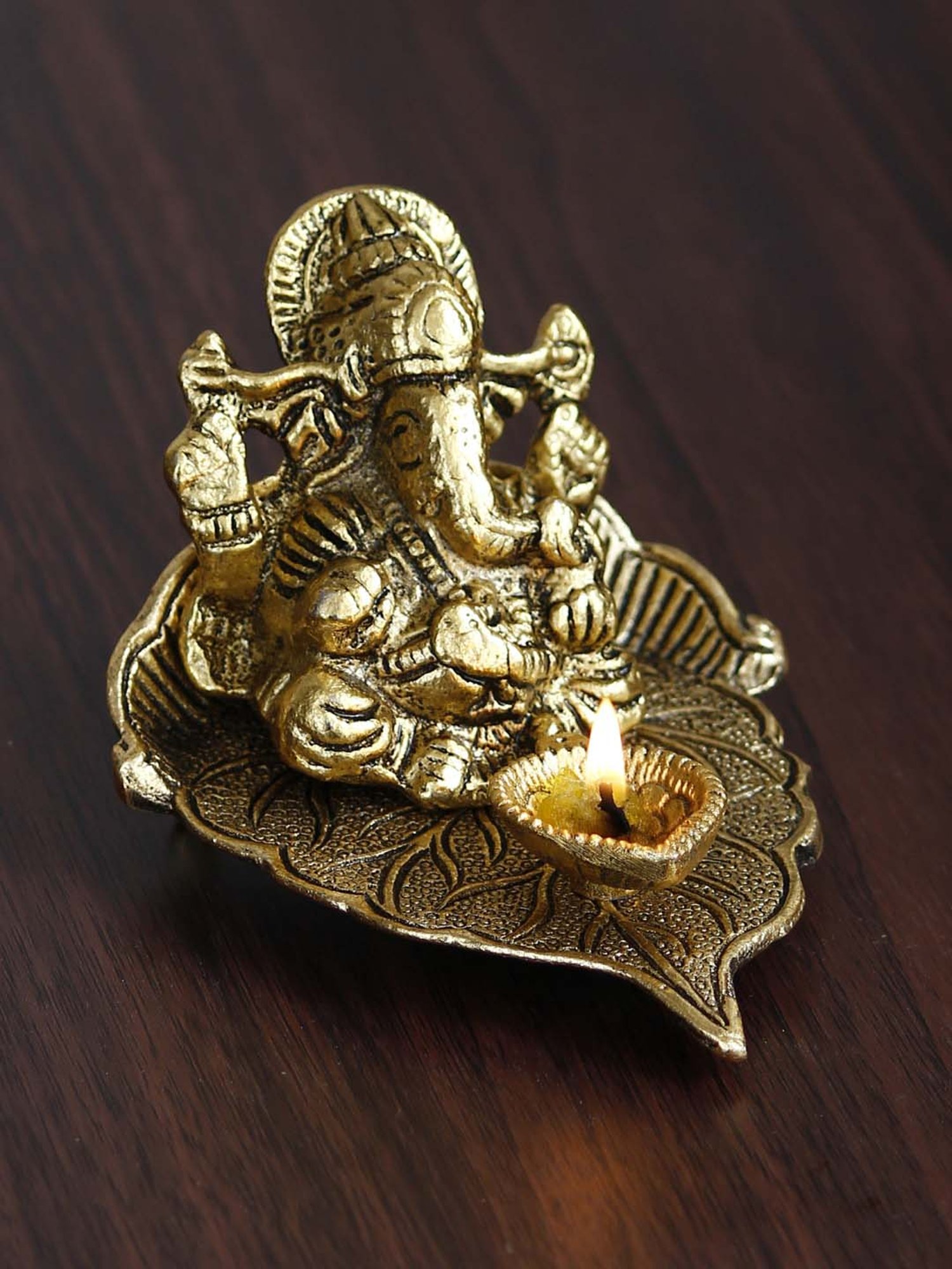 eCraftIndia Golden Lord Ganesha with Diya on Leaf Handcrafted Metal Showpiece